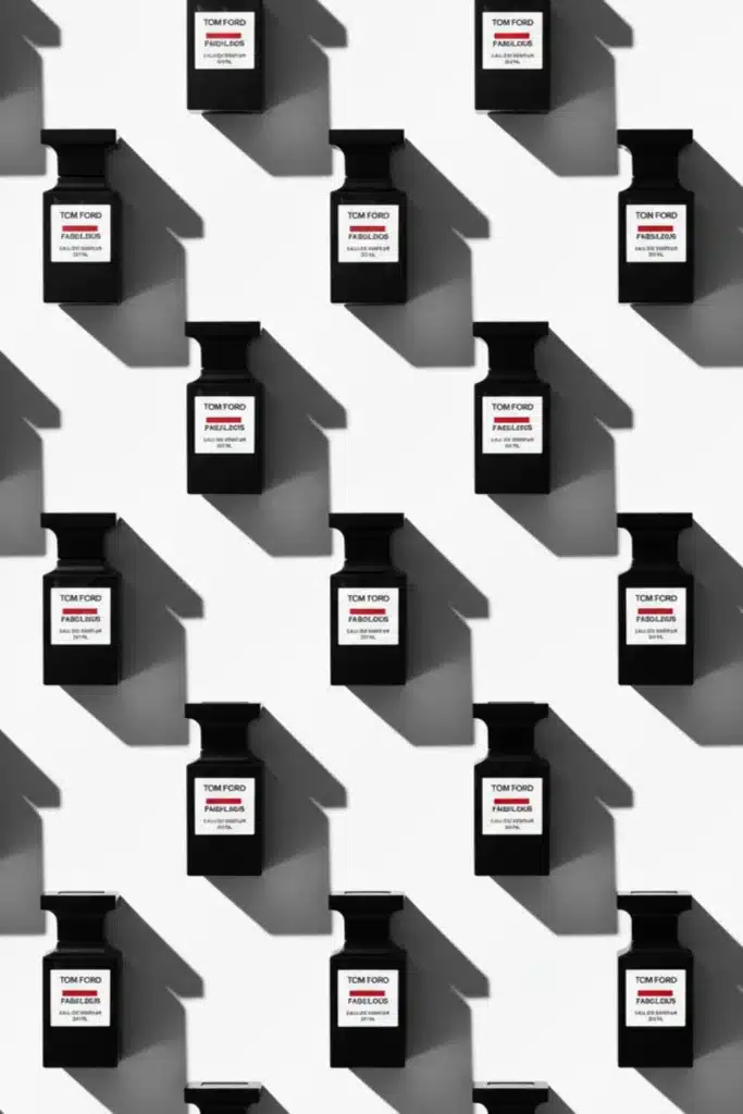 Multiple Tom Ford Fucking Fabulous perfume bottles arranged in a repeating pattern with long shadows on a white background