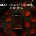 Flat lay of best fall perfumes for men styled with coffee, scarf, and autumn leaves.