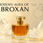 What is ambroxan in perfumery shown with a crystal bottle, marble surface, and glowing golden liquid in a modern editorial header style