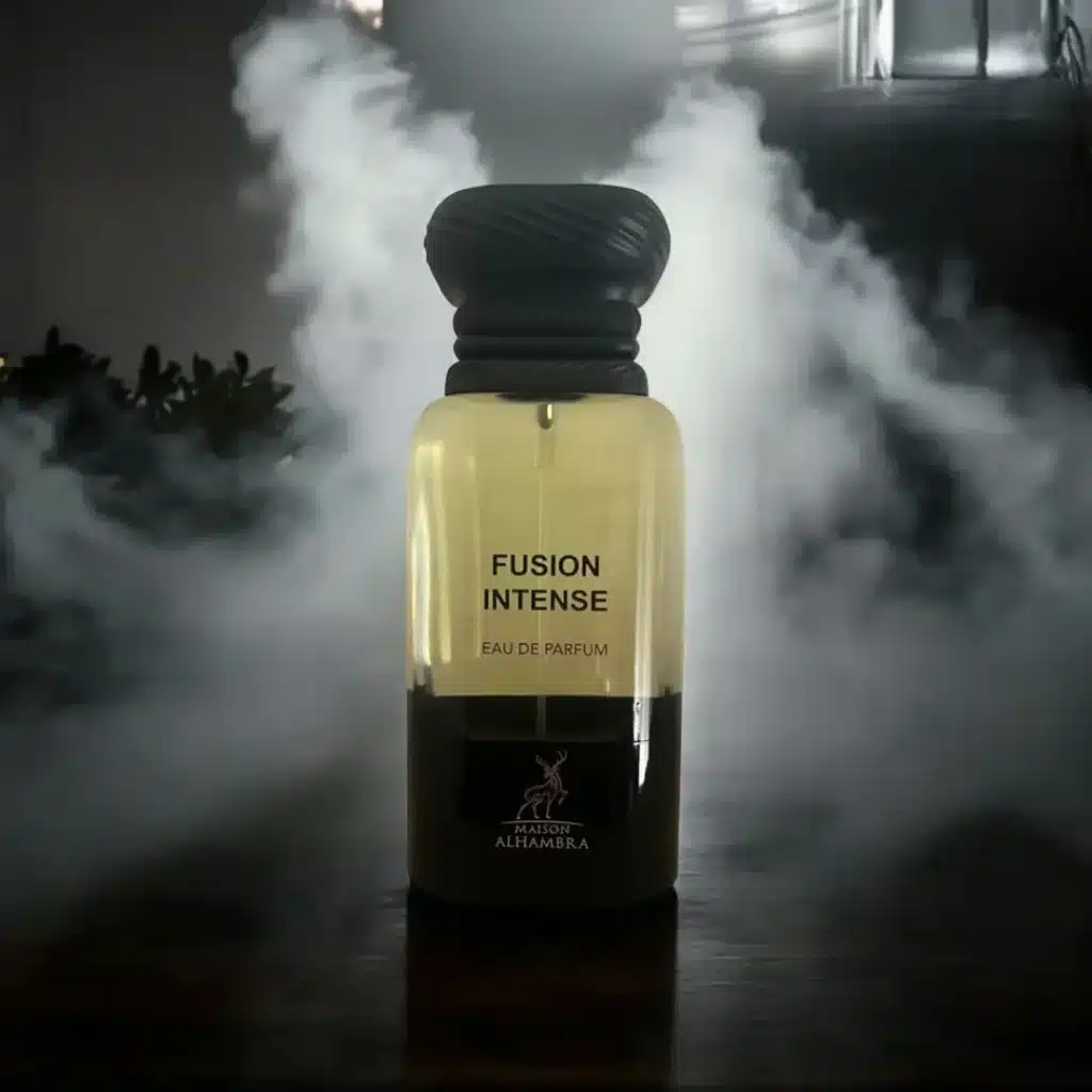 Maison Alhambra Fusion Intense perfume bottle standing on a dark surface with white smoke in the background