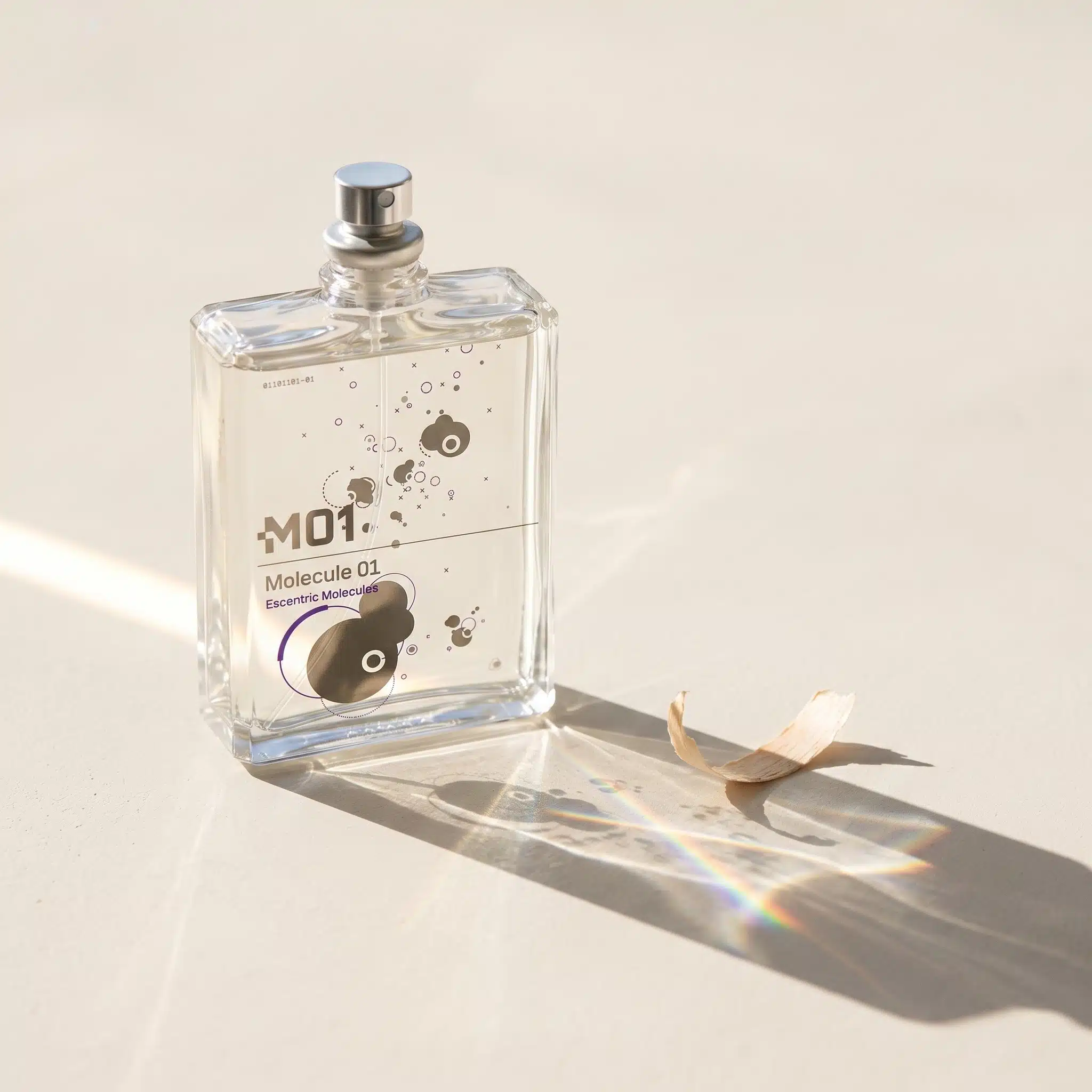 Escentric Molecules Molecule 01 clear perfume bottle with cedar shaving and rainbow prism